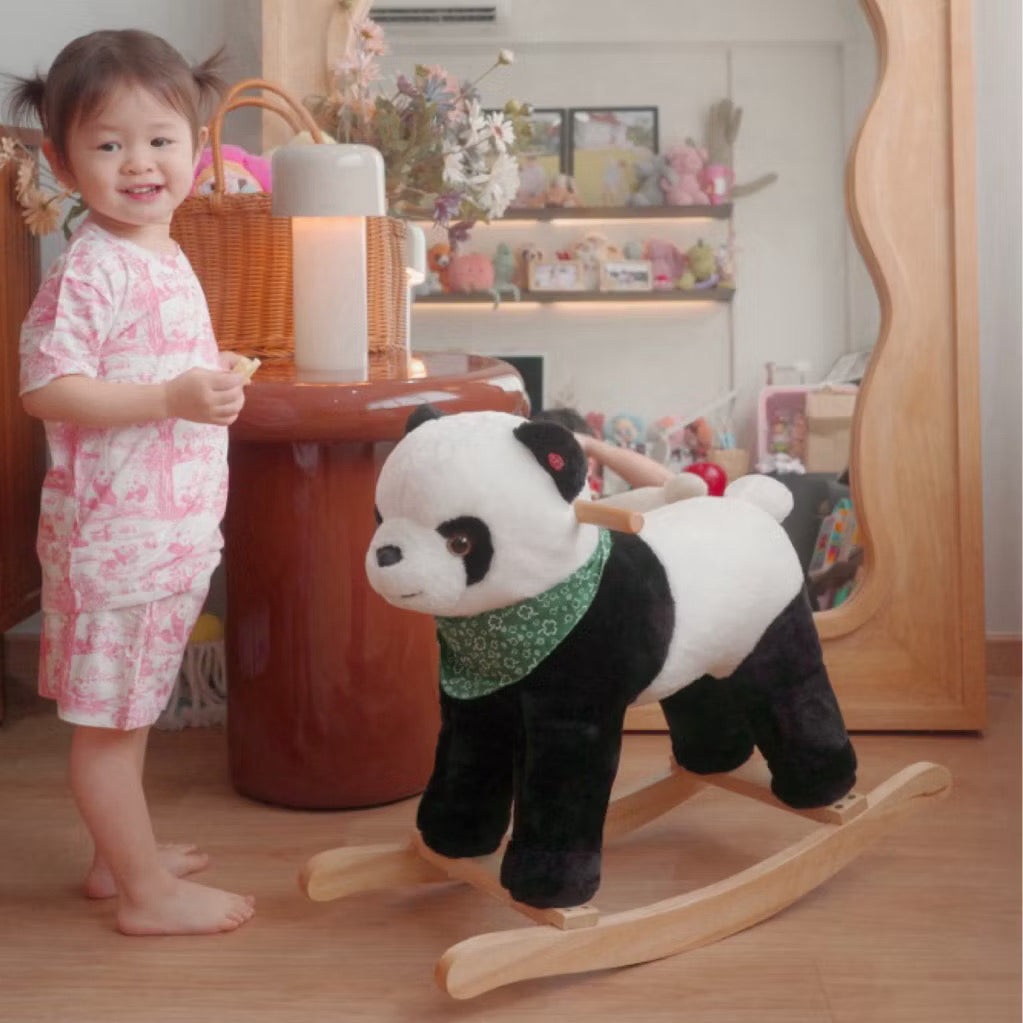 Child wearing pink short sleeve bamboo kids pyjamas set standing beside a panda-shaped rocking toy in a decorated room — soft, eczema-friendly sleepwear.