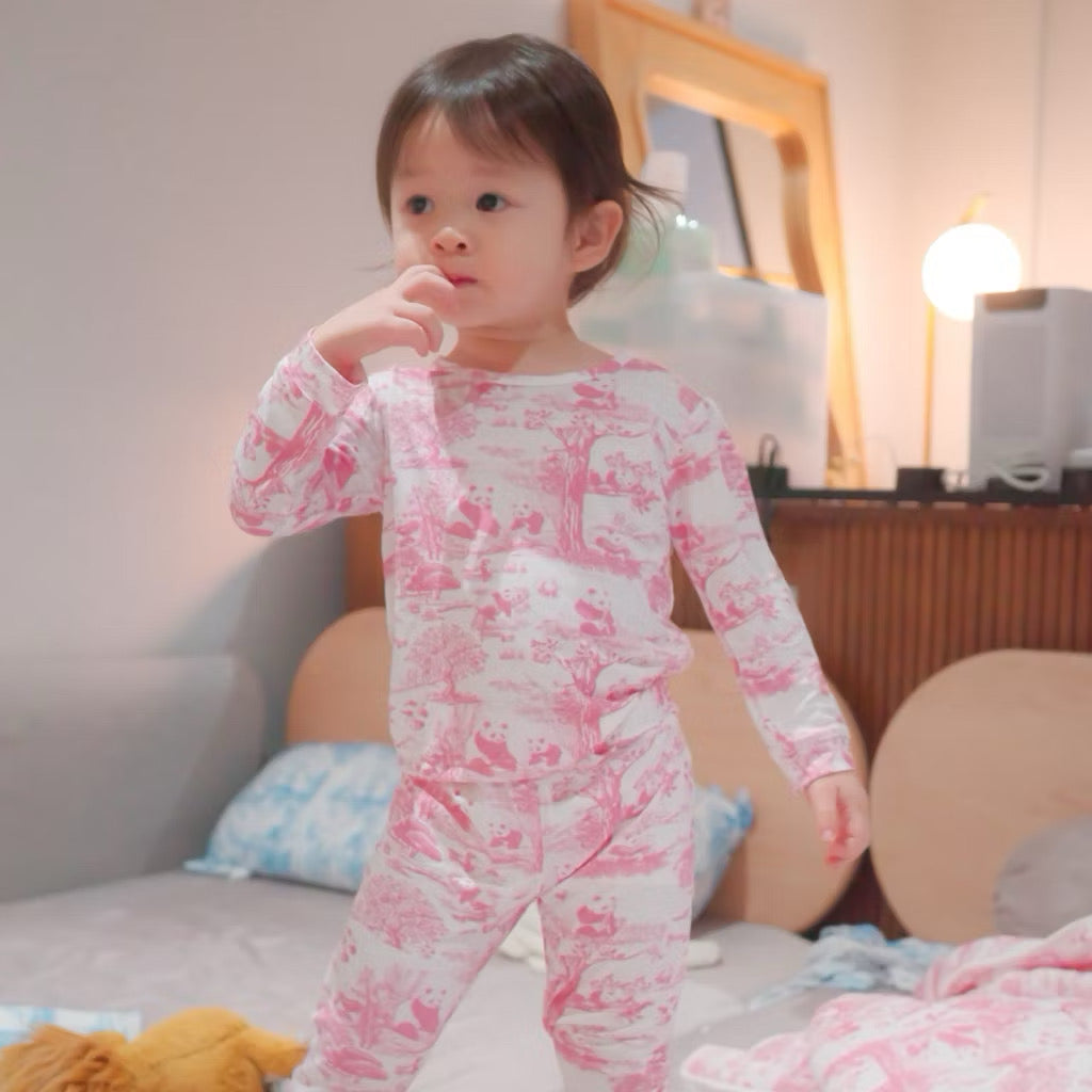 Child wearing pink and white patterned bamboo kids pyjamas in a bedroom setting — soft, breathable, eczema-friendly sleepwear.