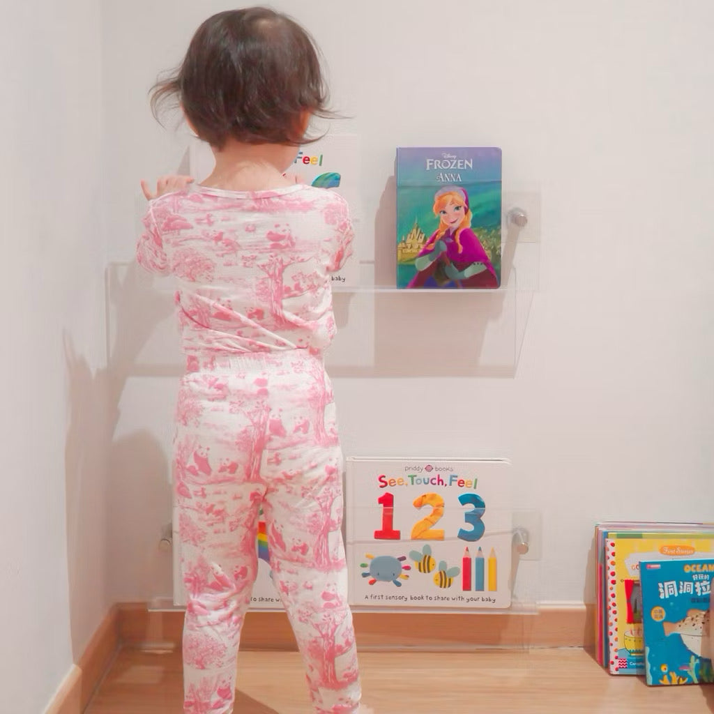 Child in bamboo pyjamas standing in front of a wall with educational posters and books — soft, cooling, eczema-friendly kids sleepwear.